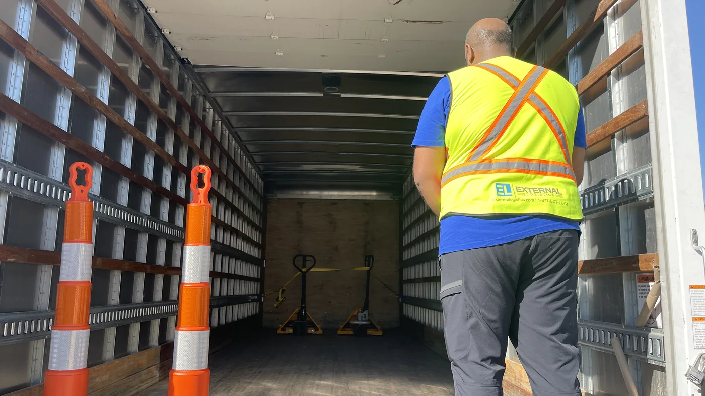 Driver preparing pallet jacks inside an External Logistics box truck